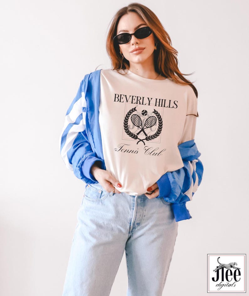 Puede incluir: Una camiseta blanca con un dise&ntilde;o gr&aacute;fico negro que dice "Beverly Hills Tennis Club" con un dise&ntilde;o de raqueta de tenis y pelota.
