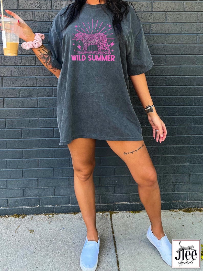 May include: A dark gray oversized t-shirt with a pink graphic of a leopard with the text "WILD SUMMER" printed on the front.