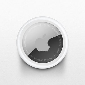 以下が含まれることがあります： Appleのロゴと「AirTag Designed by Apple in California Bluetooth LE Ultra Wideband」というテキストが書かれた白い円形のAirTag