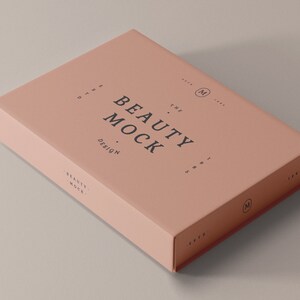 May include: A pale pink box with the text "THE BEAUTY MOCK DESIGN" printed on the top. The box is a mockup for a beauty product.