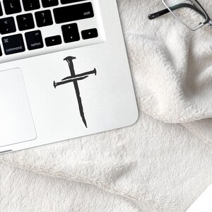 Black three nail cross vinyl decal applied to laptop, minimalist Christian cross sticker for computer or notebook