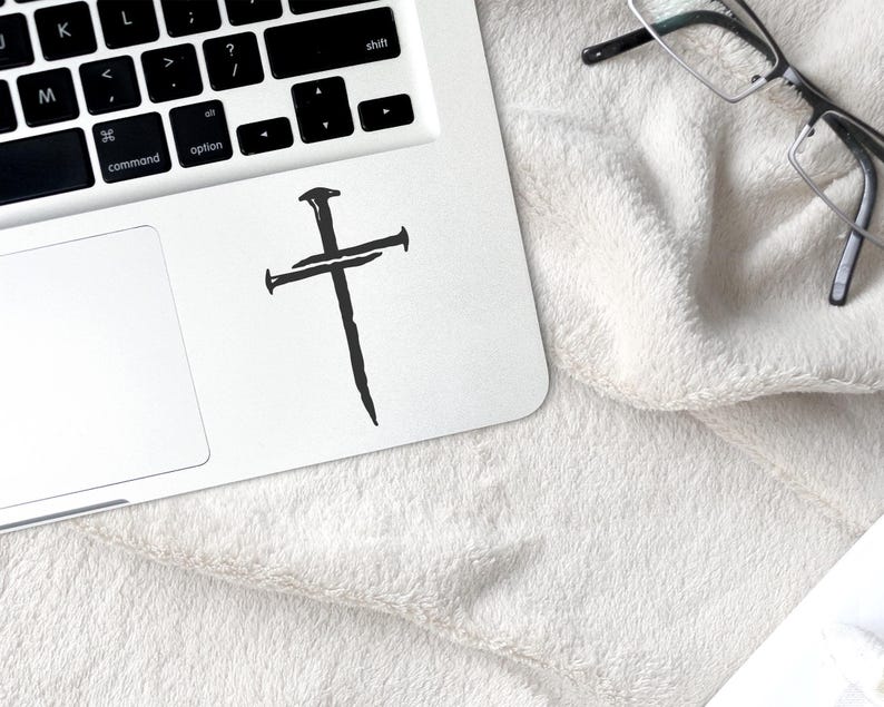 Black three nail cross vinyl decal applied to laptop, minimalist Christian cross sticker for computer or notebook