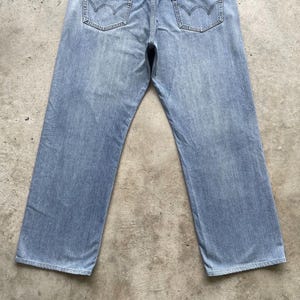 K&ouml;nnte beinhalten: Hellblaue Jeans mit klassischem F&uuml;nf-Taschen-Design. Die Jeans haben eine verwaschene Optik und einen geraden Beinverlauf. Die Ges&auml;&szlig;taschen haben ein markantes Nahtmuster. Die Jeans liegen flach auf einer neutralen Oberfl&auml;che.