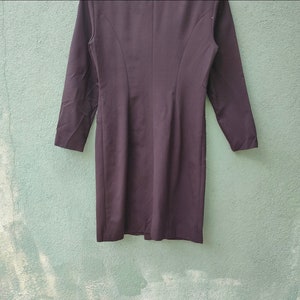 May include: A dark brown long-sleeve dress with a tailored fit. The dress features a classic design with a defined waist and a knee-length hemline. The dress is made of a smooth, solid fabric, suitable for formal or professional settings.