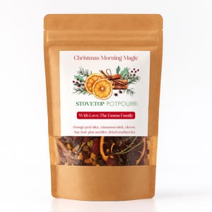 May include: A brown paper bag with a clear window displaying stovetop potpourri. The label reads "Christmas Morning Magic" and "Stovetop Potpourri." Ingredients include orange peel, cinnamon sticks, cloves, bay leaf, pine needles, and dried cranberries.