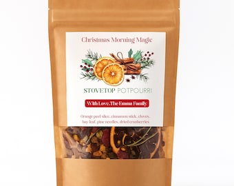 Könnte beinhalten: Ein brauner Papiersack mit einem transparenten Fenster, das Potpourri für den Herd zeigt. Das Etikett lautet "Christmas Morning Magic" und "Stovetop Potpourri". Zutaten sind Orangenschalen, Zimtstangen, Nelken, Lorbeerblätter, Kiefernnadeln und getrocknete Cranberries.