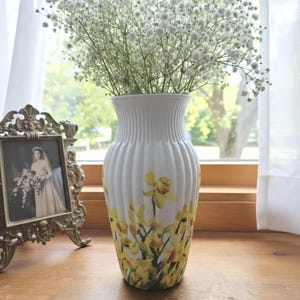 Tall large ribbed daffodil glass vase, A pretty daffodil long stemmed 26cm in height 14 cm width glass vase primed and painted in a white chalk paint providing the perfect backdrop for the decoupaged yellow daffodils all around the vase and is sure to bring a touch of nature and colour to any room