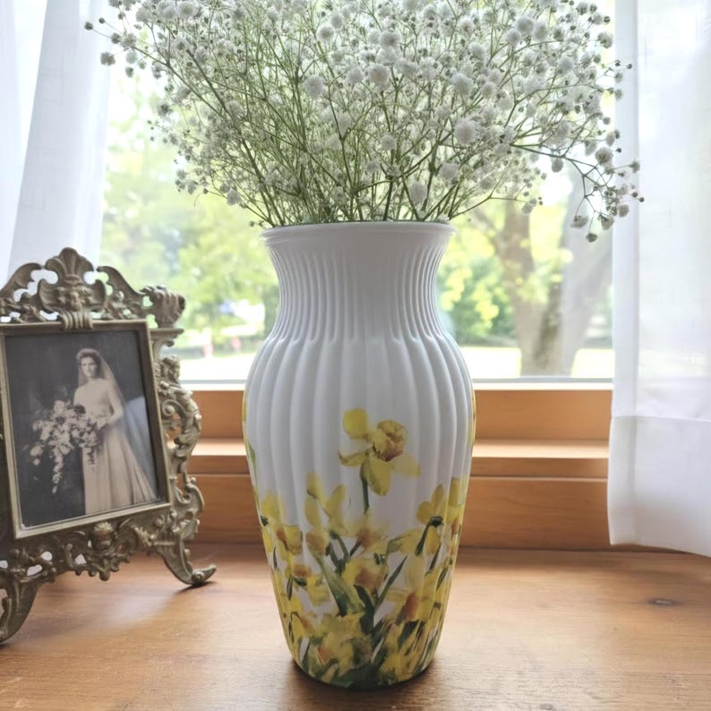 Tall large ribbed daffodil glass vase, A pretty daffodil long stemmed 26cm in height 14 cm width glass vase primed and painted in a white chalk paint providing the perfect backdrop for the decoupaged yellow daffodils all around the vase and is sure to bring a touch of nature and colour to any room