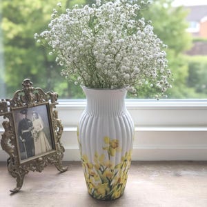 Tall large ribbed daffodil glass vase, A pretty daffodil long stemmed 26cm in height 14 cm width glass vase primed and painted in a white chalk paint providing the perfect backdrop for the decoupaged yellow daffodils all around the vase and is sure to bring a touch of nature and colour to any room