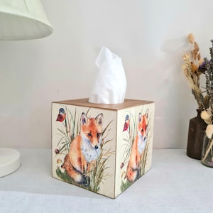 Country fox and robins luxury pine square tissue box this lovely tissue box has been primed and decoupaged in a country fox and robins design on all sides of the tissue box in a mix of greens browns reds orange cream and black with hints of gold wax gilding around the corners of the box, the top and inside the box have been waxed with a pull-out base to keep your tissues inside sealed all over to protect just wipe down with a damp cloth when needed Height 14 cm Width 15 cm Length 13 cm