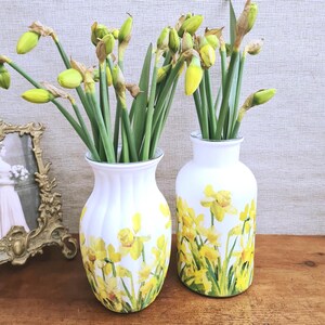 Spring Daffodils glass vase, A beautiful glass vase which has been decoupaged with vibrant yellow spring daffodils all around the vase creating a cheerful and uplifting display. set against a hand painted white chalk paint background giving it a rustic feel with natural twine tied around the vase. Height 20 cm width 11 cm