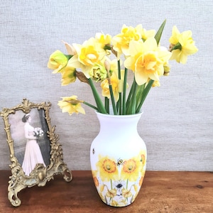 Spring daffodils tulip shaped glass vase, A pretty glass vase decoupaged with vibrant yellow daffodils with butterflies and bees amongst the flowers adding a touch of charm. against a hand painted in white chalk paint background giving a lovely rustic country feel with natural twine tied around the neck of the vase height 20 cm width 14 cm sealed to protect