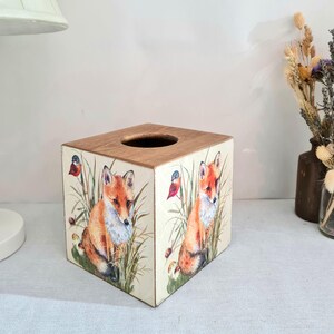 Country fox and robins luxury pine square tissue box this lovely tissue box has been primed and decoupaged in a country fox and robins design on all sides of the tissue box in a mix of greens browns reds orange cream and black with hints of gold wax gilding around the corners of the box, the top and inside the box have been waxed with a pull-out base to keep your tissues inside sealed all over to protect just wipe down with a damp cloth when needed Height 14 cm Width 15 cm Length 13 cm
