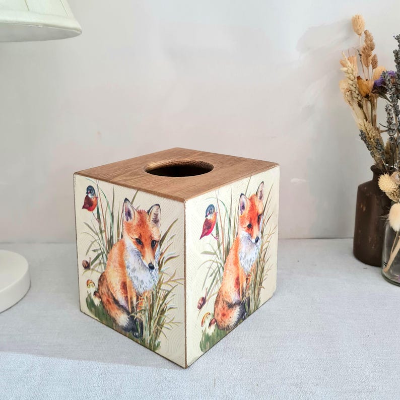 Country fox and robins luxury pine square tissue box this lovely tissue box has been primed and decoupaged in a country fox and robins design on all sides of the tissue box in a mix of greens browns reds orange cream and black with hints of gold wax gilding around the corners of the box, the top and inside the box have been waxed with a pull-out base to keep your tissues inside sealed all over to protect just wipe down with a damp cloth when needed Height 14 cm Width 15 cm Length 13 cm