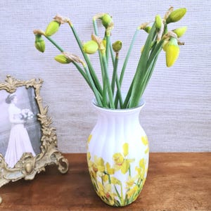 Spring Daffodils glass vase, A beautiful glass vase which has been decoupaged with vibrant yellow spring daffodils all around the vase creating a cheerful and uplifting display. set against a hand painted white chalk paint background giving it a rustic feel with natural twine tied around the vase. Height 20 cm width 11 cm