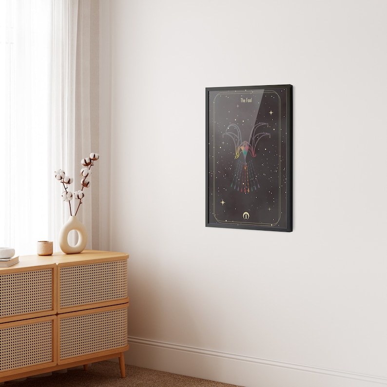 May include: A black framed print with a dark background and a colorful geometric design of a bird with the text "The Fool" at the top.