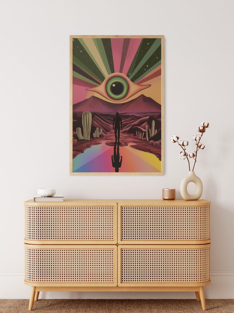 May include: A psychedelic art print featuring a large eye with a green iris and a brown pupil, surrounded by a rainbow of colours. The eye is set against a desert landscape with cacti and a lone figure walking towards it.