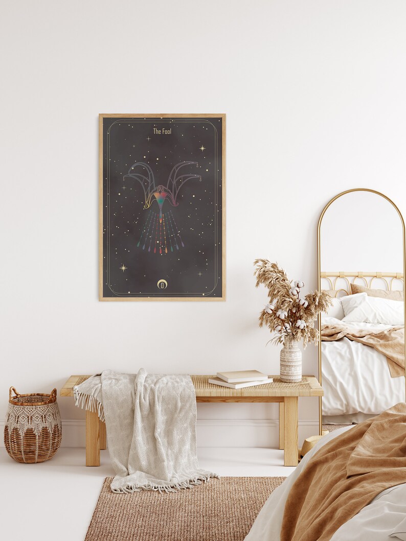 May include: A framed tarot card print with a black background and gold accents. The card depicts a stylized figure with a rainbow-colored design and the text "The Fool".