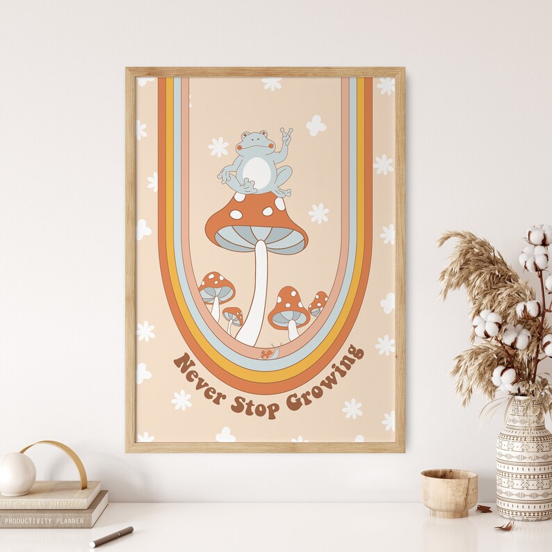May include: A framed print with a retro design featuring a blue frog sitting on a mushroom with the text "Never Stop Growing" in a rainbow arch.