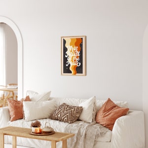 May include: A framed print with a black background and colourful abstract shapes. The text "This Must Be The Place" is written in white cursive lettering.