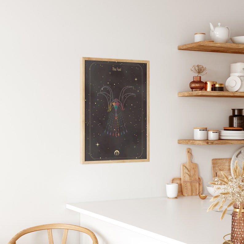 May include: A framed print with a black background and gold accents. The print features a geometric design with a rainbow color scheme and the text "The Fool".