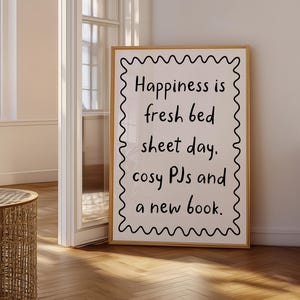 May include: A white framed poster with black text that reads "Happiness is fresh bed sheet day. cosy PJs and a new book."