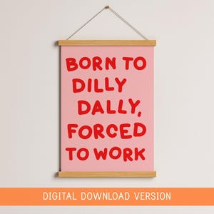 May include: A pink wall hanging with the text "BORN TO DILLY DALLY, FORCED TO WORK" in red. The print is held by a wooden frame and suspended by a string. The words "DIGITAL DOWNLOAD VERSION" are at the bottom.