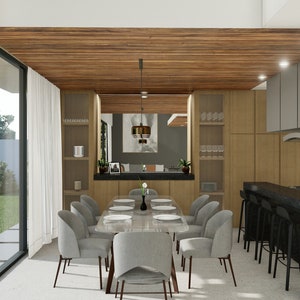 Puede incluir: Vista interior de un comedor y una cocina modernos. El comedor cuenta con una mesa rectangular con sillas grises. La cocina tiene gabinetes de madera, una encimera negra y electrodom&eacute;sticos de acero inoxidable. Grandes ventanales ofrecen vistas al exterior.