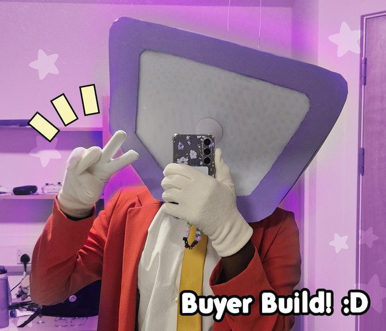 May include: A person wearing a red blazer, white gloves, and a yellow tie, holding a phone. The person is wearing a large, square-shaped headpiece with a purple border. The image includes the text "Buyer Build! :D".