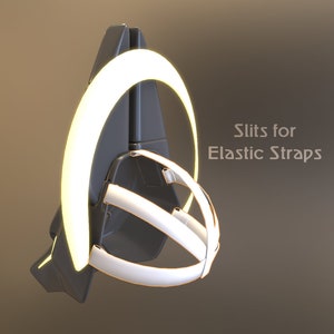 May include: A black and white helmet with a white ring around the top. The ring has slits for elastic straps. "Slits for Elastic Straps" is written in white text on the right side of the image.