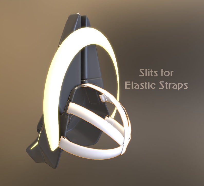 May include: A black and white helmet with a white ring around the top. The ring has slits for elastic straps. "Slits for Elastic Straps" is written in white text on the right side of the image.