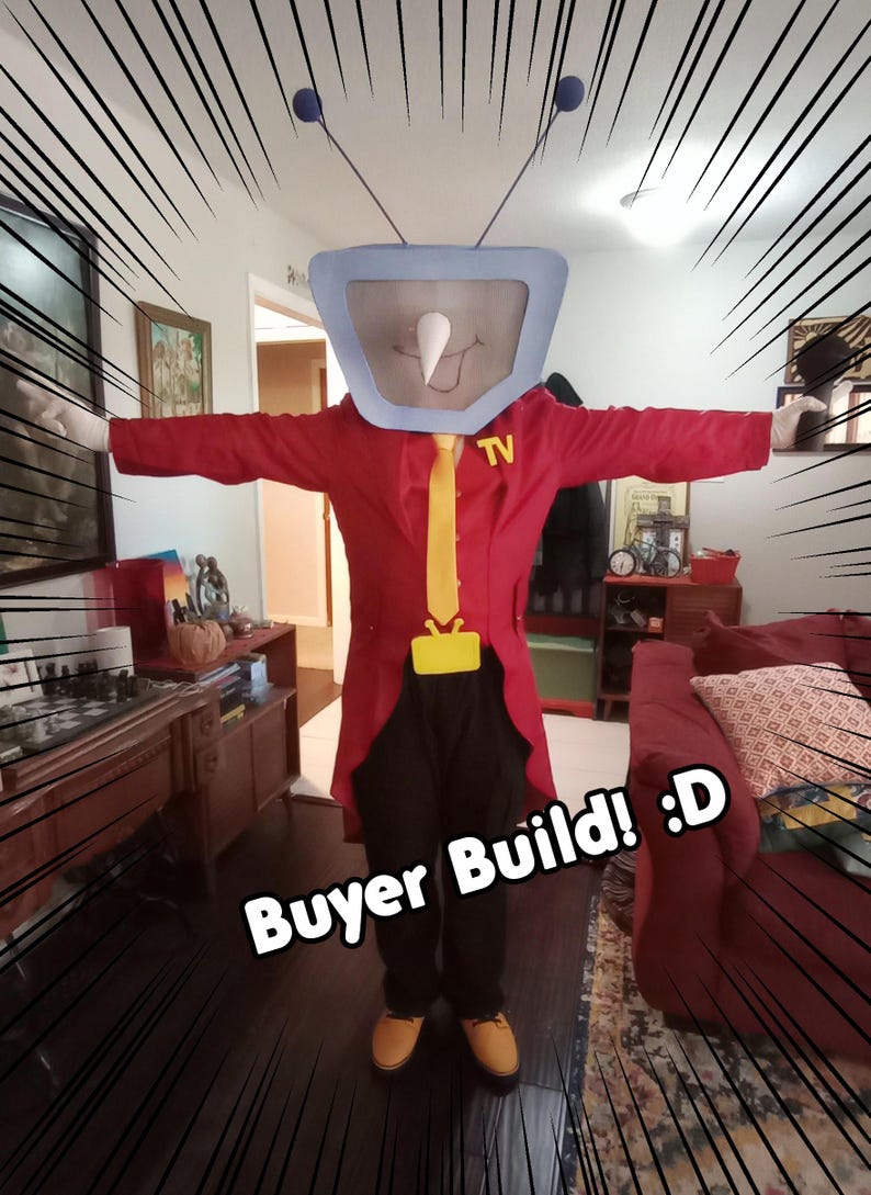 May include: A person in a TV costume with a red coat, yellow tie, and black trousers. The TV head is light blue with a white nose and antenna. The text "Buyer Build! :D" is visible.