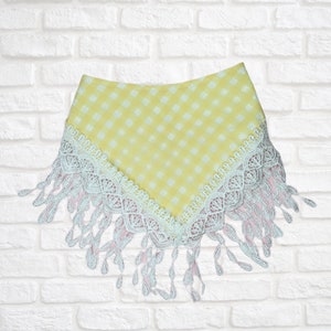 May include: Yellow and white gingham bandana with a pink and white lace trim and fringe.