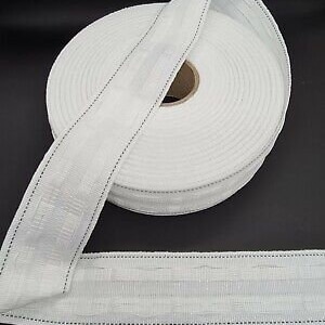 May include: White curtain tape with a textured pattern and a black stitching detail. The tape is rolled up on a spool.