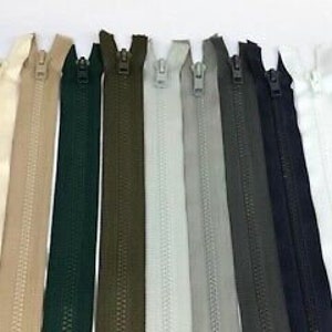 May include: Assortment of 12 zipper closures in various colours, including red, beige, tan, green, olive, grey, and black. The zippers are all closed and laid out in a row.