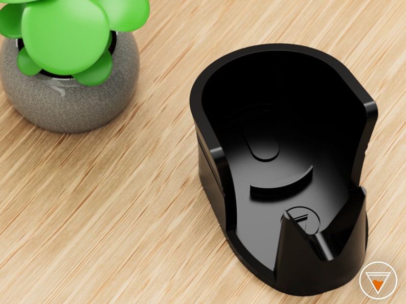 May include: A black plastic holder for a charging cable. The holder has a curved shape and a small opening on the side.