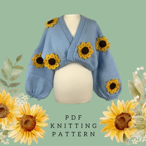 May include: A light blue knitted bolero sweater with yellow and brown sunflower appliqués. The sweater has a V-neck and long, puffy sleeves. The text "PDF KNITTING PATTERN" is printed in black.