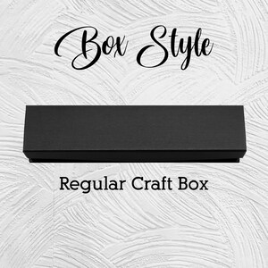 Puede incluir: Una caja artesanal rectangular negra con una superficie texturizada. Las palabras "Box Style" est&aacute;n escritas en cursiva encima de la caja, y "Regular Craft Box" debajo, todo sobre un fondo blanco texturizado.