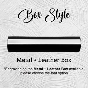 Puede incluir: Una caja de metal y cuero negra con una franja plateada. El texto "Box Style" est&aacute; encima de la caja, y "Metal + Leather Box" debajo. El texto tambi&eacute;n menciona opciones de grabado.