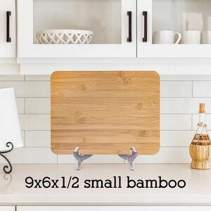 May include: A small, rectangular bamboo cutting board, measuring 9x6x1/2 inches, displayed on a countertop. The board has a natural wood grain pattern. The text "9x6x1/2 small bamboo" is printed at the bottom.