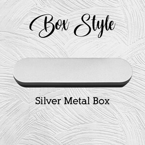 Puede incluir: Una caja de metal plateado con bordes redondeados, sobre un fondo blanco texturizado. El texto "Box Style" est&aacute; escrito en cursiva encima de la caja, y "Silver Metal Box" est&aacute; escrito debajo.