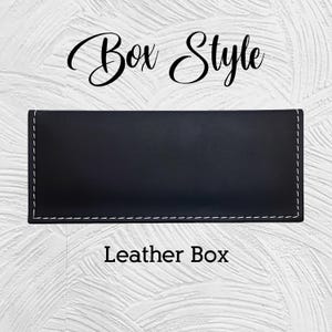 Puede incluir: Una caja rectangular de cuero negro con costuras blancas en los bordes. El texto "Box Style" est&aacute; escrito en cursiva en la parte superior y "Leather Box" en la inferior.