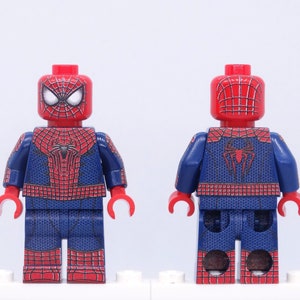K&ouml;nnte beinhalten: Zwei Lego Spider-Man-Minifiguren, eine nach vorne und eine nach hinten gerichtet. Die Figuren haben rot-blaue Kost&uuml;me mit Spinnennetz-Design. Der Kopf ist rot mit wei&szlig;en Augen. Die vordere Figur zeigt das Spinnenemblem auf der Brust.