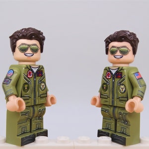 Puede incluir: Dos minifiguras LEGO personalizadas de un piloto que lleva un traje de vuelo verde con parches, cabello casta&ntilde;o y gafas de sol de aviador.
