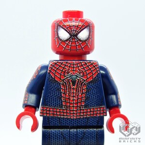 K&ouml;nnte beinhalten: Eine rote und blaue Spider-Man Lego-Minifigur. Die Minifigur hat einen roten Kopf mit wei&szlig;en Augen und einem schwarzen Netzdesign. Der Torso und die Arme sind blau mit einem roten Netzdesign. Die H&auml;nde sind rot.