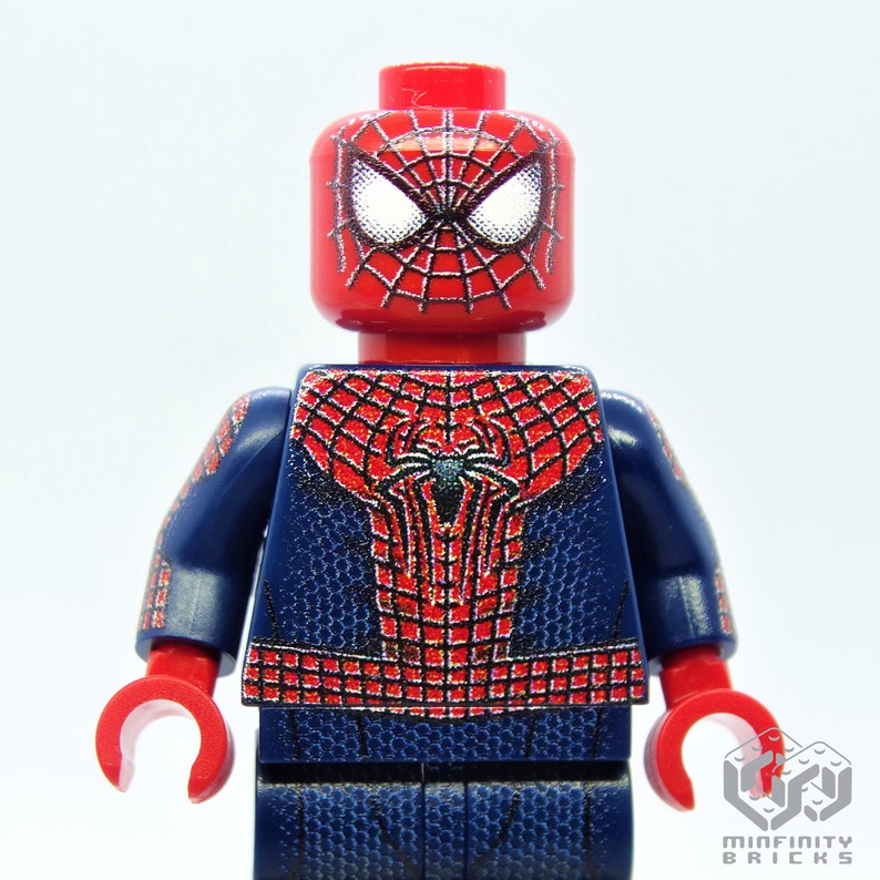 K&ouml;nnte beinhalten: Eine rote und blaue Spider-Man Lego-Minifigur. Die Minifigur hat einen roten Kopf mit wei&szlig;en Augen und einem schwarzen Netzdesign. Der Torso und die Arme sind blau mit einem roten Netzdesign. Die H&auml;nde sind rot.