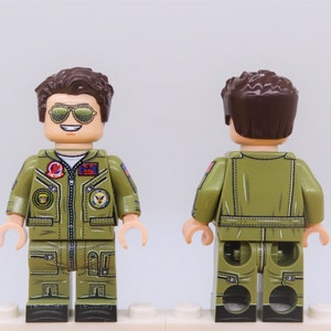 Puede incluir: Una minifigura LEGO personalizada de un piloto que lleva un traje de vuelo verde con parches, cabello casta&ntilde;o y gafas de sol. La minifigura se muestra de frente y de espalda.