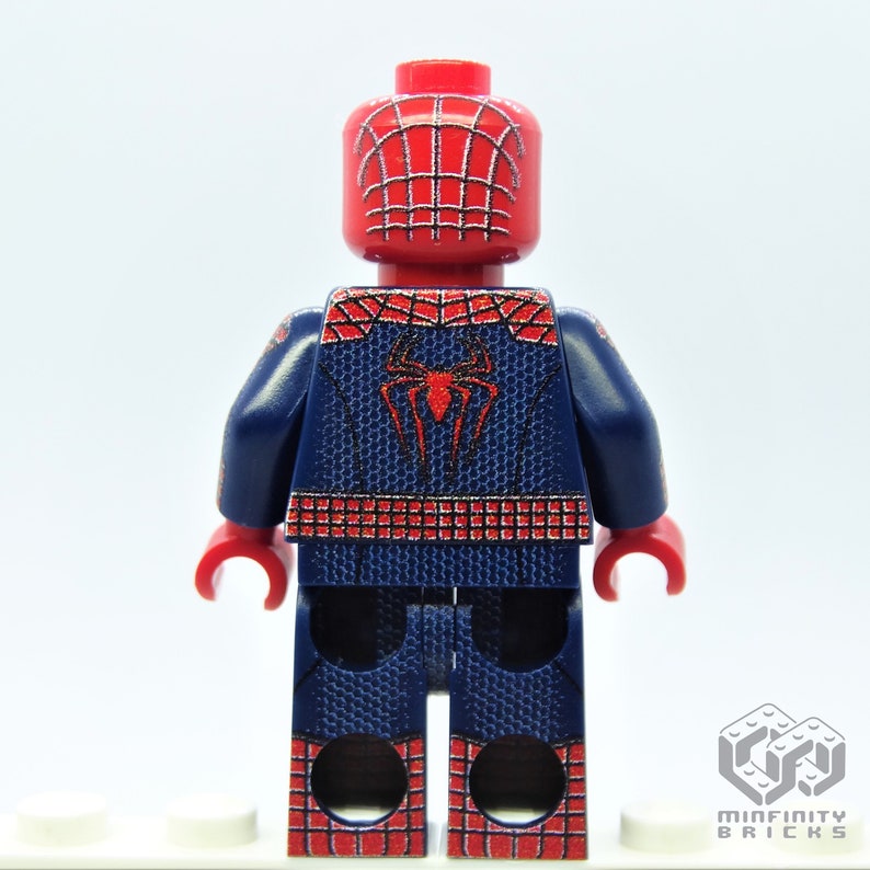 K&ouml;nnte beinhalten: Eine rote und blaue Spider-Man Lego-Minifigur. Die Figur hat einen roten Kopf mit Spinnennetz-Design und einen blauen Anzug mit einem Spinnenemblem auf dem R&uuml;cken. Die Beine und Arme der Figur sind ebenfalls rot und blau.