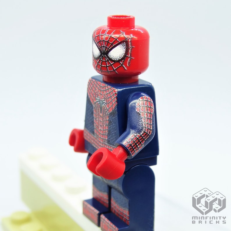 K&ouml;nnte beinhalten: Eine Lego-Minifigur von Spider-Man. Der Kopf ist rot mit einem schwarzen Spinnennetz-Design und wei&szlig;en Augen. Der Anzug ist blau und rot mit einem Spinnennetz-Muster. Rote H&auml;nde vervollst&auml;ndigen das Design.