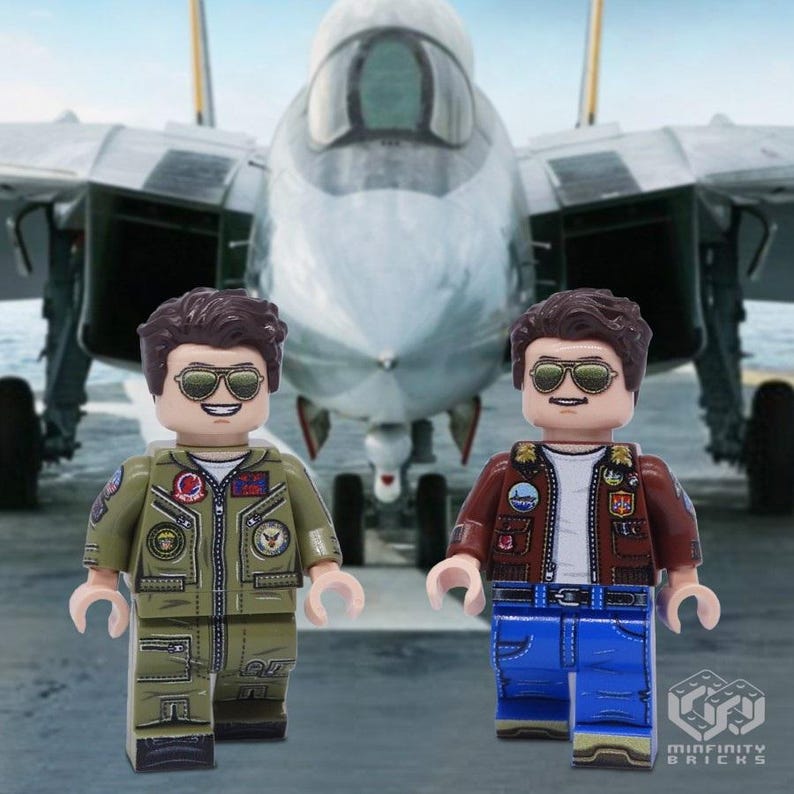 Puede incluir: Dos minifiguras Lego de pilotos que llevan gafas de aviador y trajes de vuelo. Una minifigura lleva un traje de vuelo verde con parches y la otra lleva una chaqueta de cuero marr&oacute;n con parches y pantalones vaqueros azules. Las minifiguras est&aacute;n de pie frente a un avi&oacute;n de combate gris.